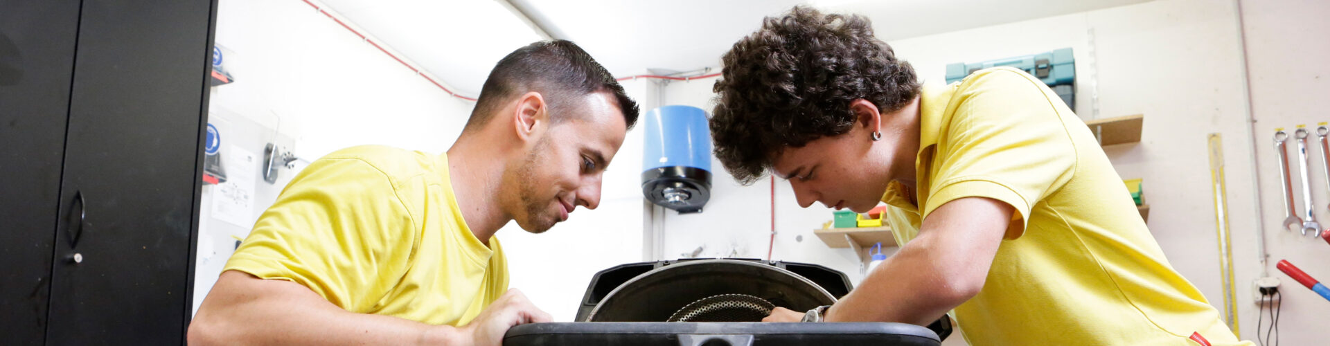 Arbeitsagoge und Lernender bei der Reparatur einer Gerätschaft