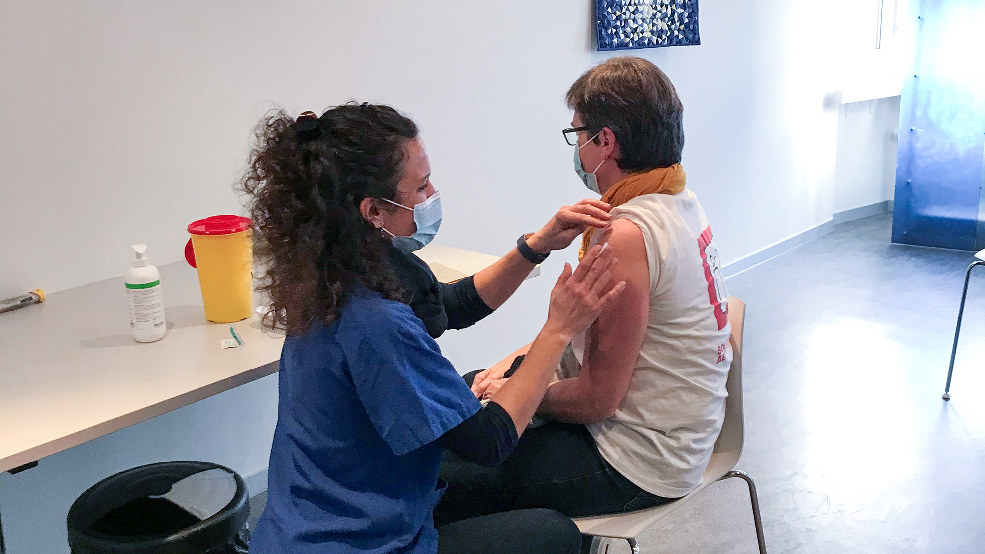 Pflegerein bereitet Frau auf die Impfung vor