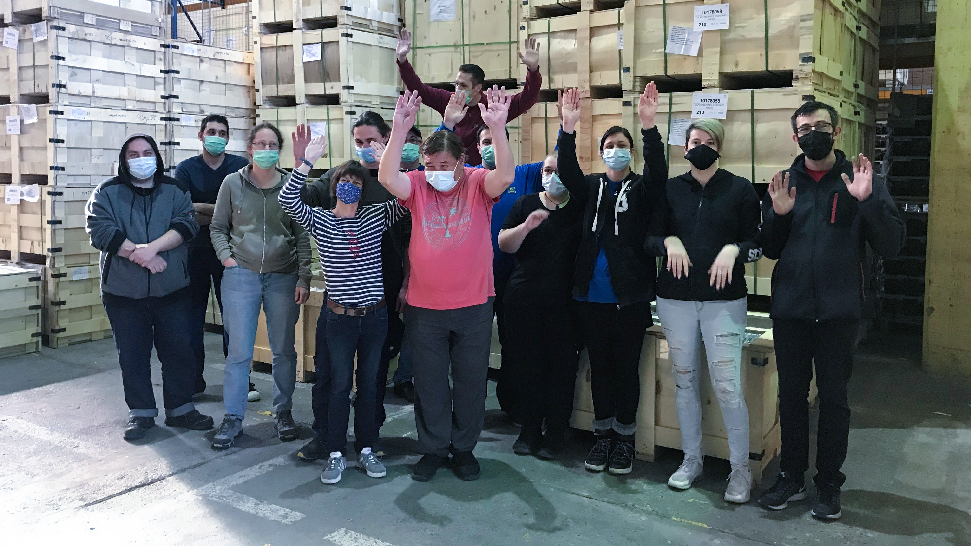 Team Aussendienstgruppe jubelnd in der Lagerhalle