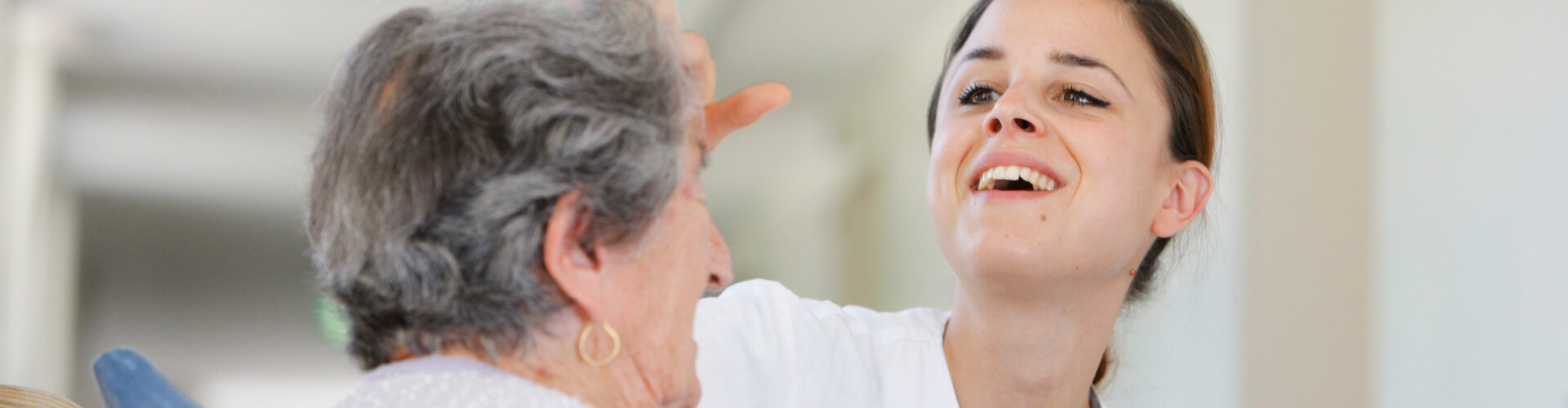 Auszubildende Pflegefachfrau bei der Betreuung einer Seniorin